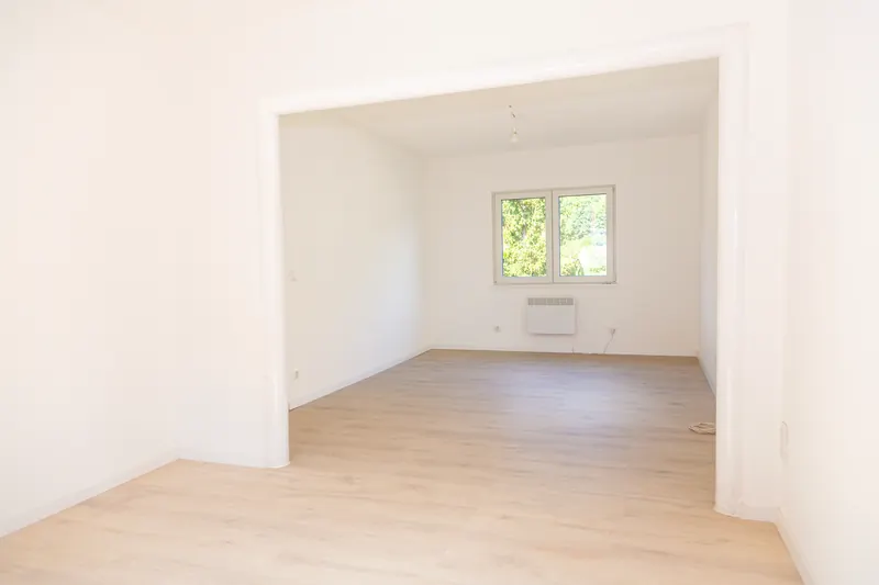 Renoviertes Wohnzimmer im Erdgeschoss mit hellem Boden und weißen Wänden, eigenes Haus in Alpirsbach